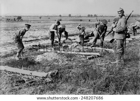 English WW1 POWs prisoners at work near Doberitz, Germany. 1914-15. Deep within eastern Germany they labor with shovels under an armed guard.