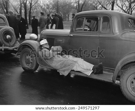 Seamen protest against the Copeland Safety-At-Sea Act. Jan. 18, 1937. One striker takes a nap on an auto running board as his mates protest.