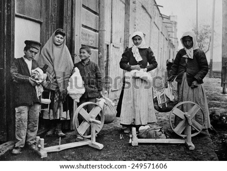 Armenian women and boys with spinning wheels and cotton. Ca. 1915-21. This is possibly a refugee family receiving tools to make a living in Yerevan, Armenia.