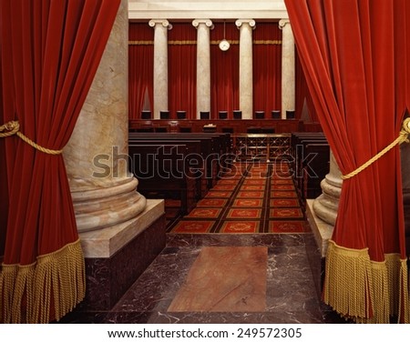 Interior of the U.S. Supreme Court, Washington, D.C. Ca. 1990. The seats of the nine justices are viewed from the draped chamber entrance.