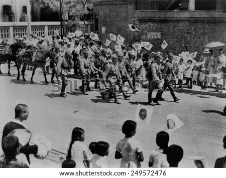 Japanese residents of Beijing, China, welcome Japanese invaders. Men, Women and children wave flags and shout \'Banzai\' to invading Japanese troops, 1937.