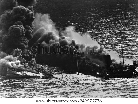 Allied tanker torpedoed in Atlantic Ocean by German submarine during World War 2. The ship crumbled amidships under heat of fire as she settled toward bottom of sea. 1942.