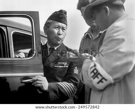 Japanese-American veteran, dressed in his WW2 uniform, reports for his WW2 internment. Santa Anita Park assembly, Arcadia, California, April 5, 1942. Photo by Dorothea Lange.