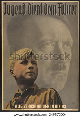 \'Youth serves the leader - all ten year-olds into the Hitler Youth\'. Poster shows German boy wearing Hitler Youth uniform, with portrait of Adolf Hitler behind him. 1941.