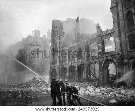 Fire fighting during WW2 Battle of Britain. Firemen at work in bomb-damaged street in London, after Saturday night raid, ca. 1941.