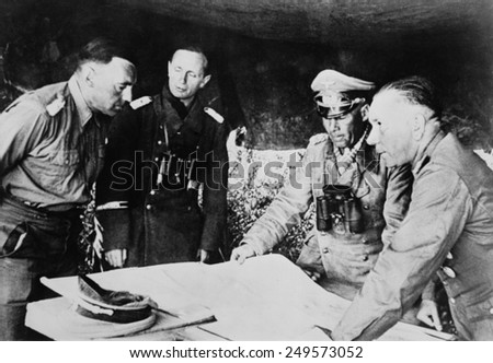 Field Marshal Erwin Rommel confers with his staff on the Libyan front, July 1942. He was fighting the British in the First Battle of El Alamein, July 1-27, 1942.