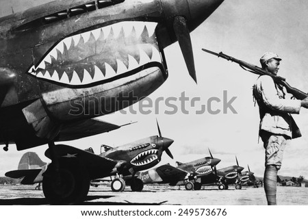 Chinese soldier guards a line of American P-40 fighter planes, ca. 1942. The shark-face fighters of the 'Flying Tigers' had a 12-to-1 victory ratio over the Japanese planes during World War 2.