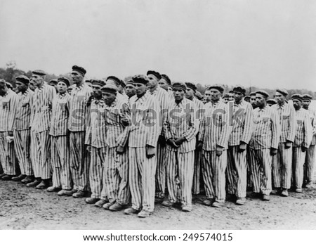 Roll call at Buchenwald concentration camp, ca.1938-1941. Two prisoners in the foreground are supporting a comrade, as fainting was frequently an excuse for the guards to \'liquidate\' useless inmates.