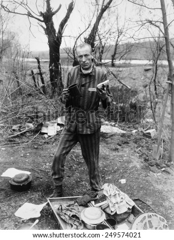 Belgian prisoner in German slave labor camp at Nordhausen, at time of liberation by U.S. Army. Prisoner holds a daily ration of a small cup of soup and a slice of bread. April 1945.