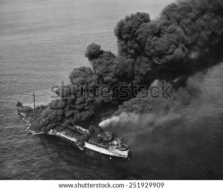 A torpedoed American tanker burning after an Axis submarine attack. Crew members brought the fire under control and the ship was towed to port for repair. Ca. 1942-43. World War 2.