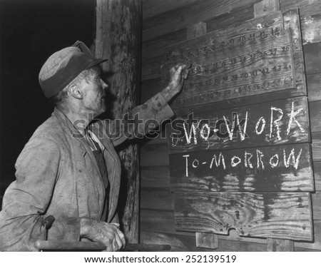 A coal loader putting up his check at the end of day\'s work on Friday, Sept. 13, 1946. \'No Work Tomorrow\' with \'N\' written backwards. Harlan County, Kentucky. Photo by Russell Lee.