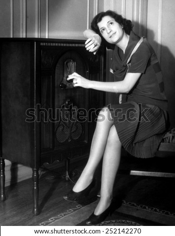 Woman listening to a radio, c. 1930s.