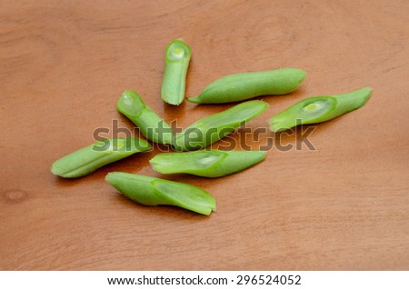 bunch of cut string beans on wooden board