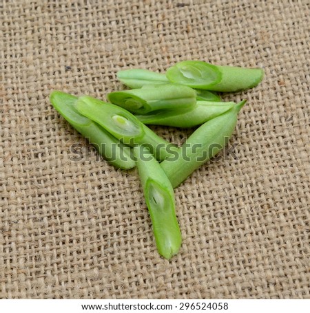 bunch of cut string beans on wooden board