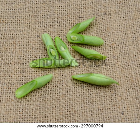 heap of cut string beans on wooden board