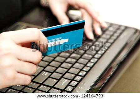 Hands entering credit card information into a laptop