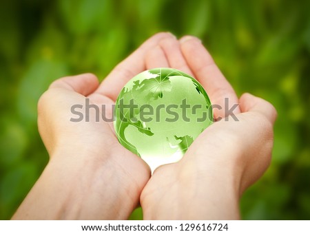 human hands carefully holding Earth planet. Glass World