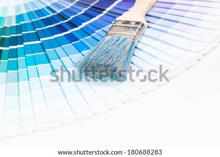 Paintbrushes and blue color samples over white background.