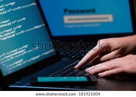 Hacker using laptop. Lots of digits on the computer screen.