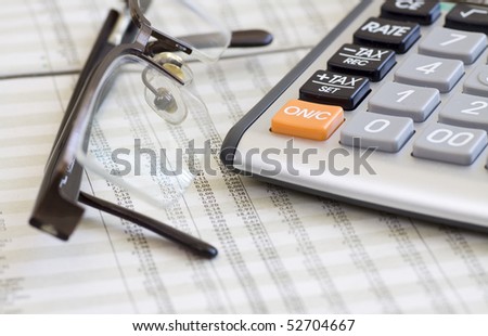 A calculator, glasses, and financial statement. Selective focus.