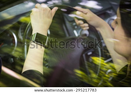 A woman uses smartwatch in the car. Smart watch concept.