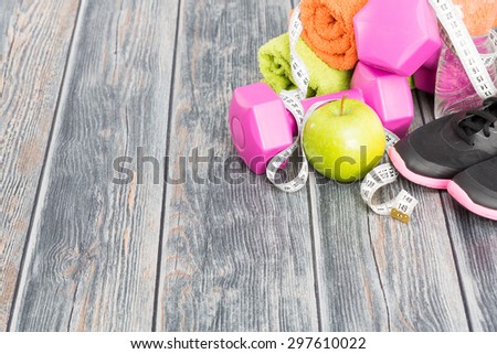 Fitness equipment and healthy nutrition on wood background.