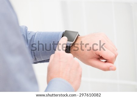Businessman uses smart watch and phone. Smartwatch concept.