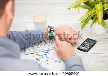Businessman uses smart watch and phone. Smartwatch concept.