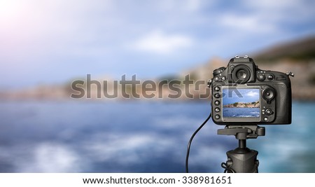 Digital camera on day view. Photography sea and city in the background.