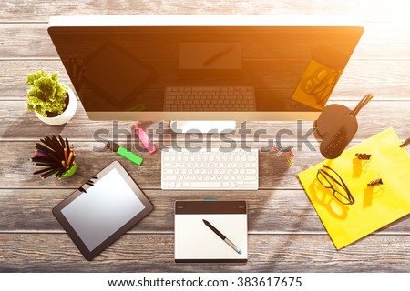 Office workplace with tablet and pc on wood table.