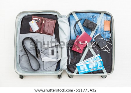 travel traveler traveling bag top open view packing card camera packed credit wallet clothing table leaving departure concept