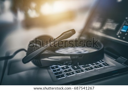 Communication support, call center and customer service help desk. VOIP headset on laptop computer keyboard.