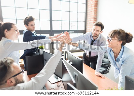 Business people happy showing team work and giving five in office. Teamwork concepts.