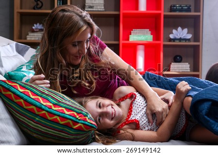 Mother and daughters in everyday scenes waking up her daughter