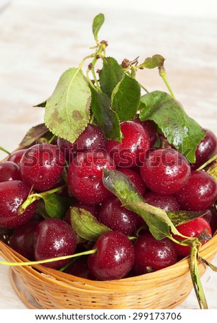 Organic cherries in a basket on the table with the water droplets