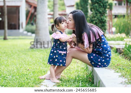 mother and daughter kiss in the garden
