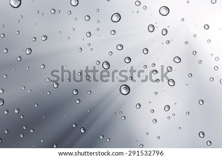 Water drop lighting flare on glass mirror background texture.