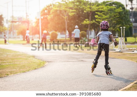 Young couples roller skates outdoor in park.