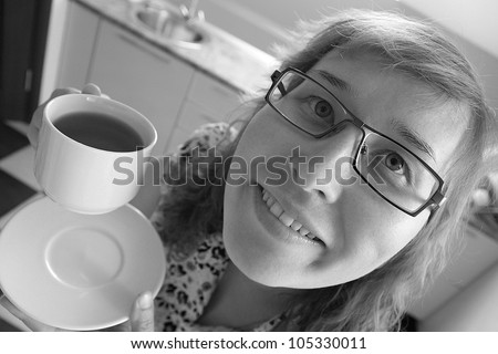 A smiling young woman holding a cup of tea/Tea in the morning gives me a good mood!