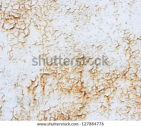 A rusty old metal plate with cracked white gloss paint. Old rusty white metallic background.