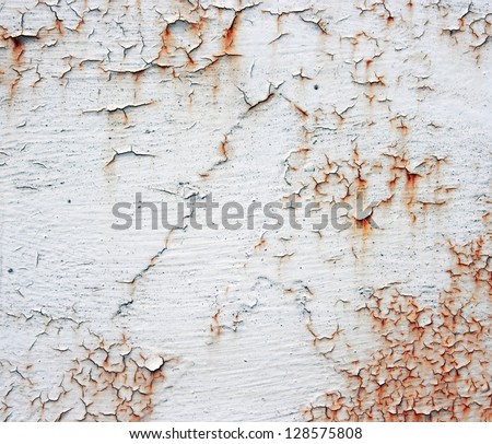 A rusty old metal plate with cracked white gloss paint. Old rusty white metallic background.