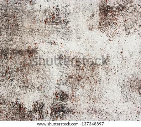A rusty old metal plate with white paint. Old rusty metallic background.