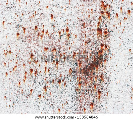 Old rusty metallic background with a white paint.