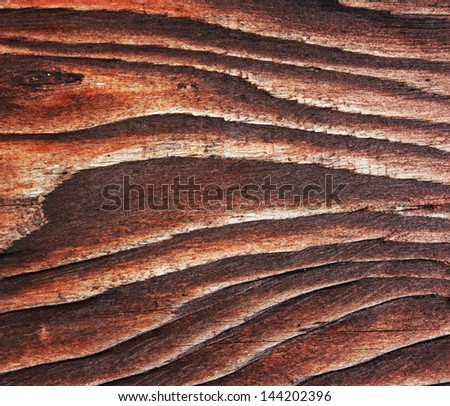 Brown wooden board close-up. Dark wooden background.