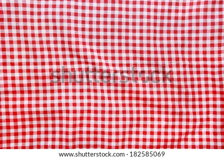 Texture of a red and white checkered picnic blanket. Red linen crumpled tablecloth.