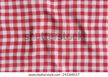 Red linen crumpled tablecloth. Texture of a red and white checkered picnic blanket.