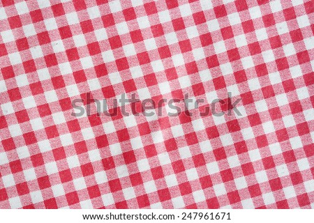 Texture of a red and white checkered tablecloth. Red linen crumpled picnic blanket.