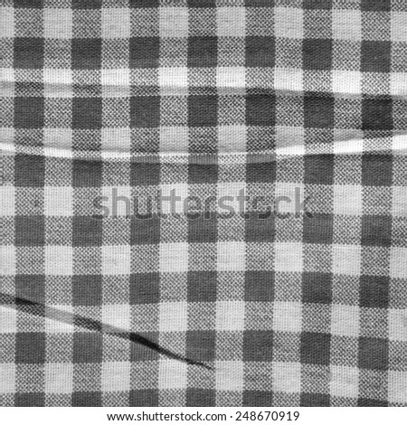 Texture of a black and white checkered picnic blanket. Gray linen crumpled tablecloth.