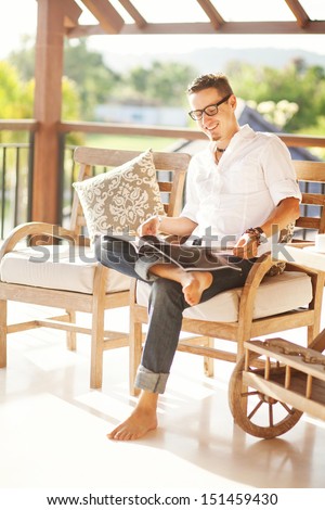 man reading magazine at home