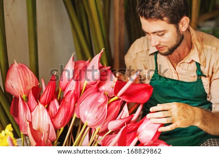 handsome florist in his flower shop (focus on his eyes)